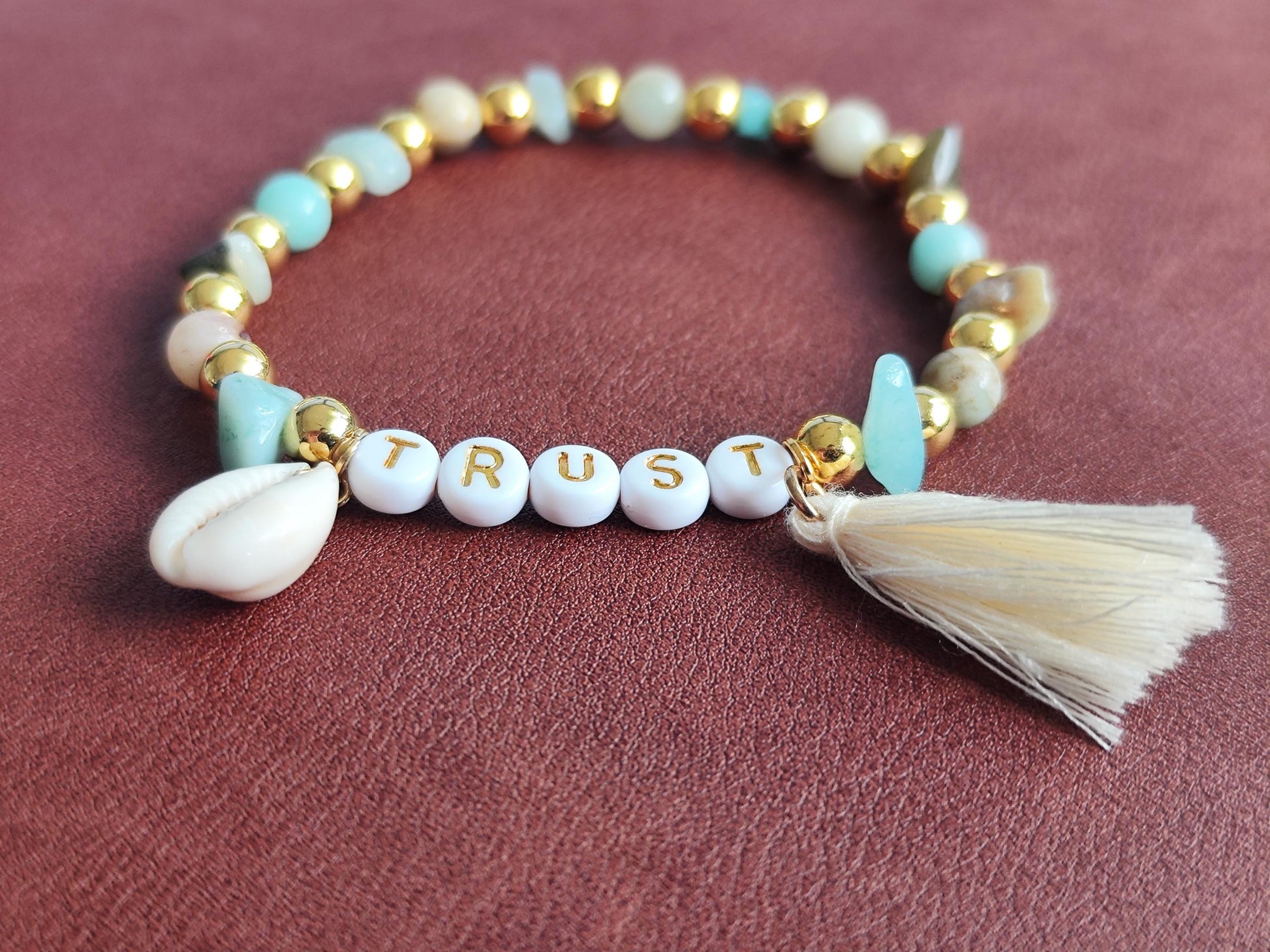 TRUST Armband – mit Edelsteinen, goldfarbenen Perlen, Muschel & Quaste | Boho Schmuck handgemacht