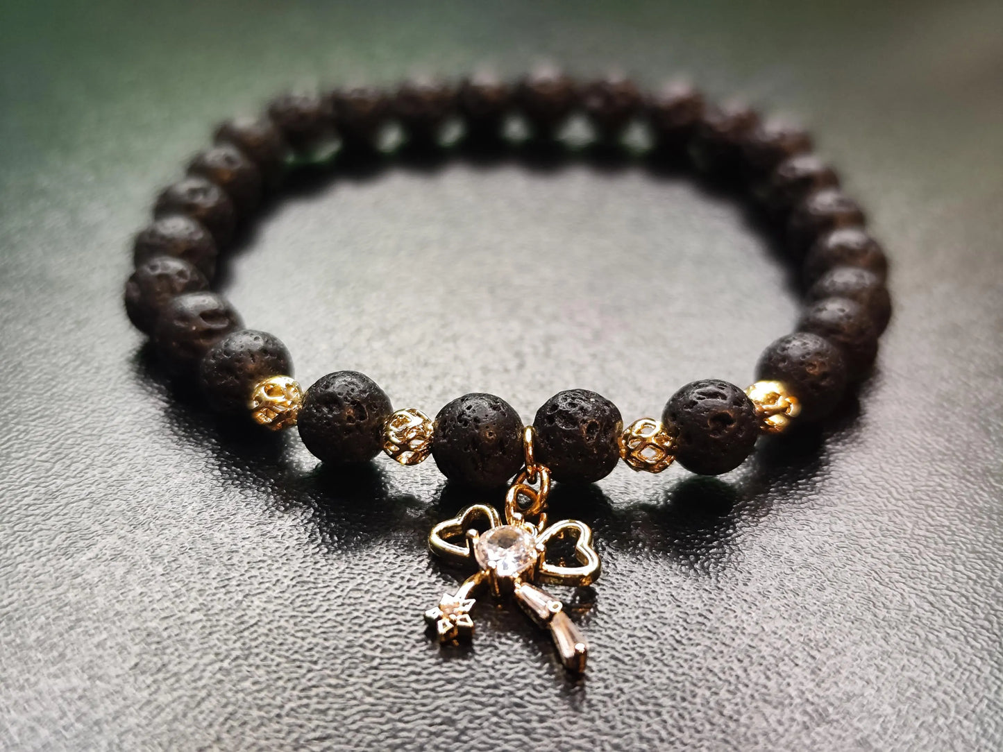 Lava Armband mit 18k vergoldetem Schleifen-Charm – Handgemachtes Schmuckstück für Stärke & Schutz