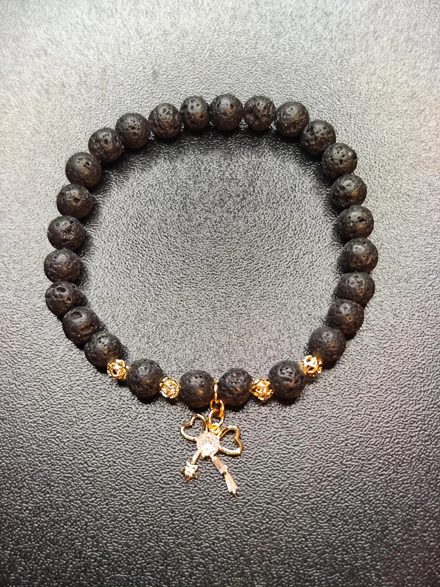 Lava Armband mit 18k vergoldetem Schleifen-Charm – Handgemachtes Schmuckstück für Stärke & Schutz