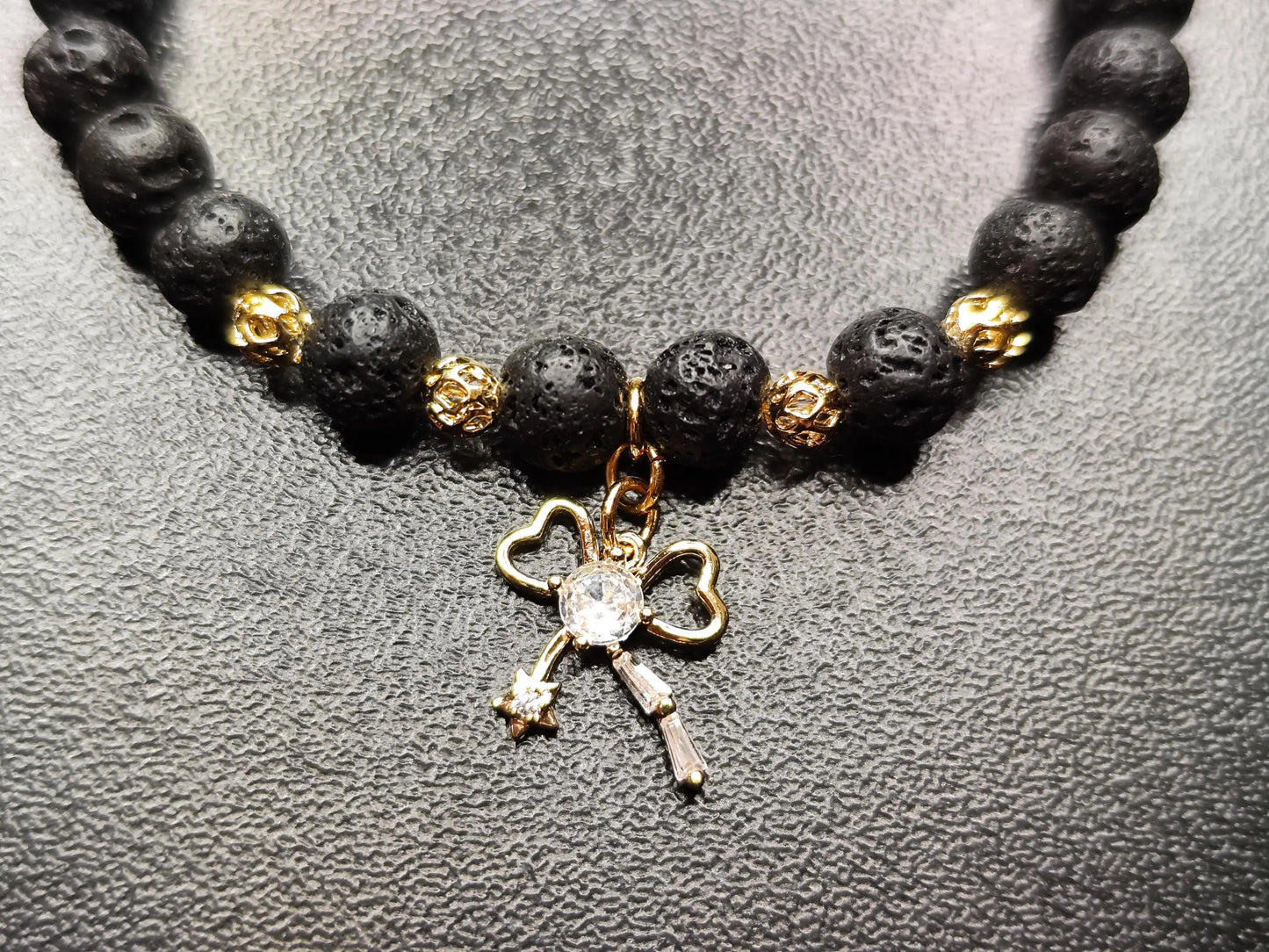 Lava Armband mit 18k vergoldetem Schleifen-Charm – Handgemachtes Schmuckstück für Stärke & Schutz