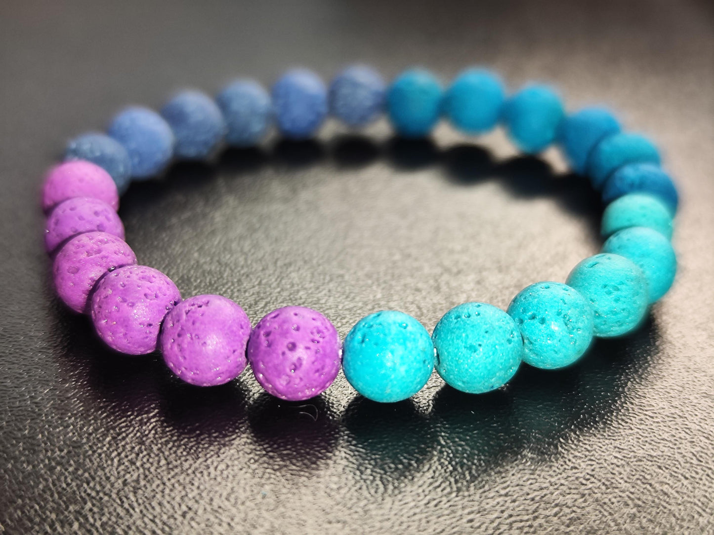 Handgemachtes Armband aus gefärbtem Lavastein in Blau, Türkis & Lila – Duftarmband – Elastisch u. natürlich